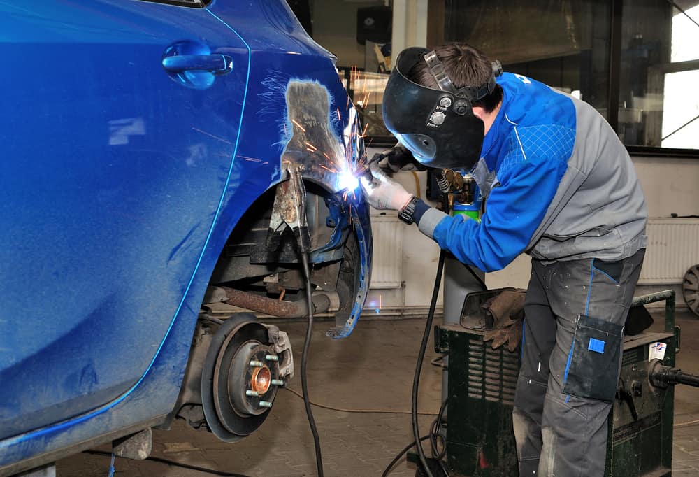 image of a mechanic working on the body of a car