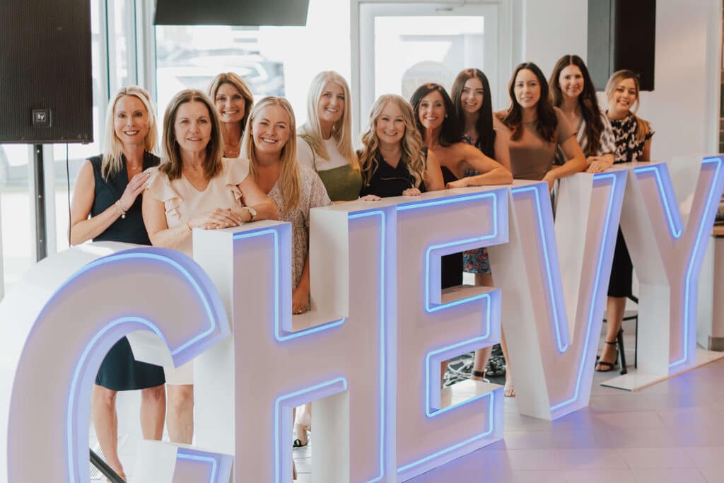 image of a group of women in front of a Chevy sign