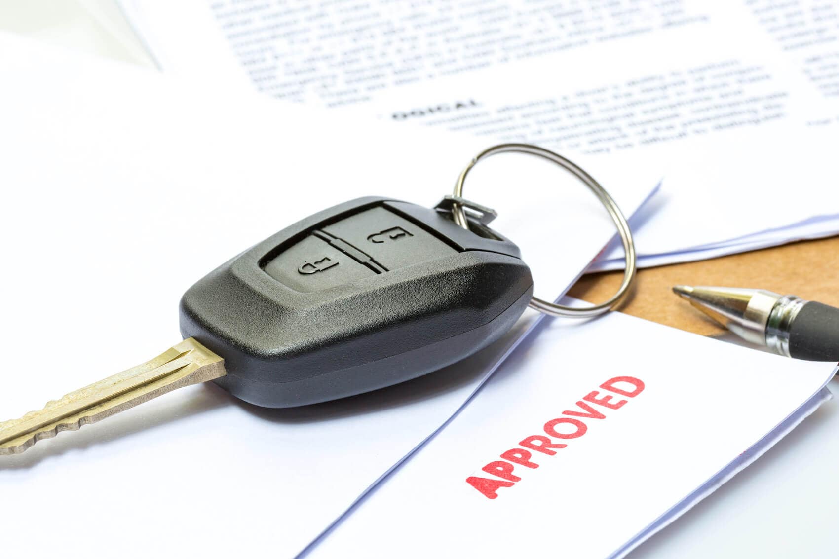 image of a car key on a stack of papers that say 'Approve'