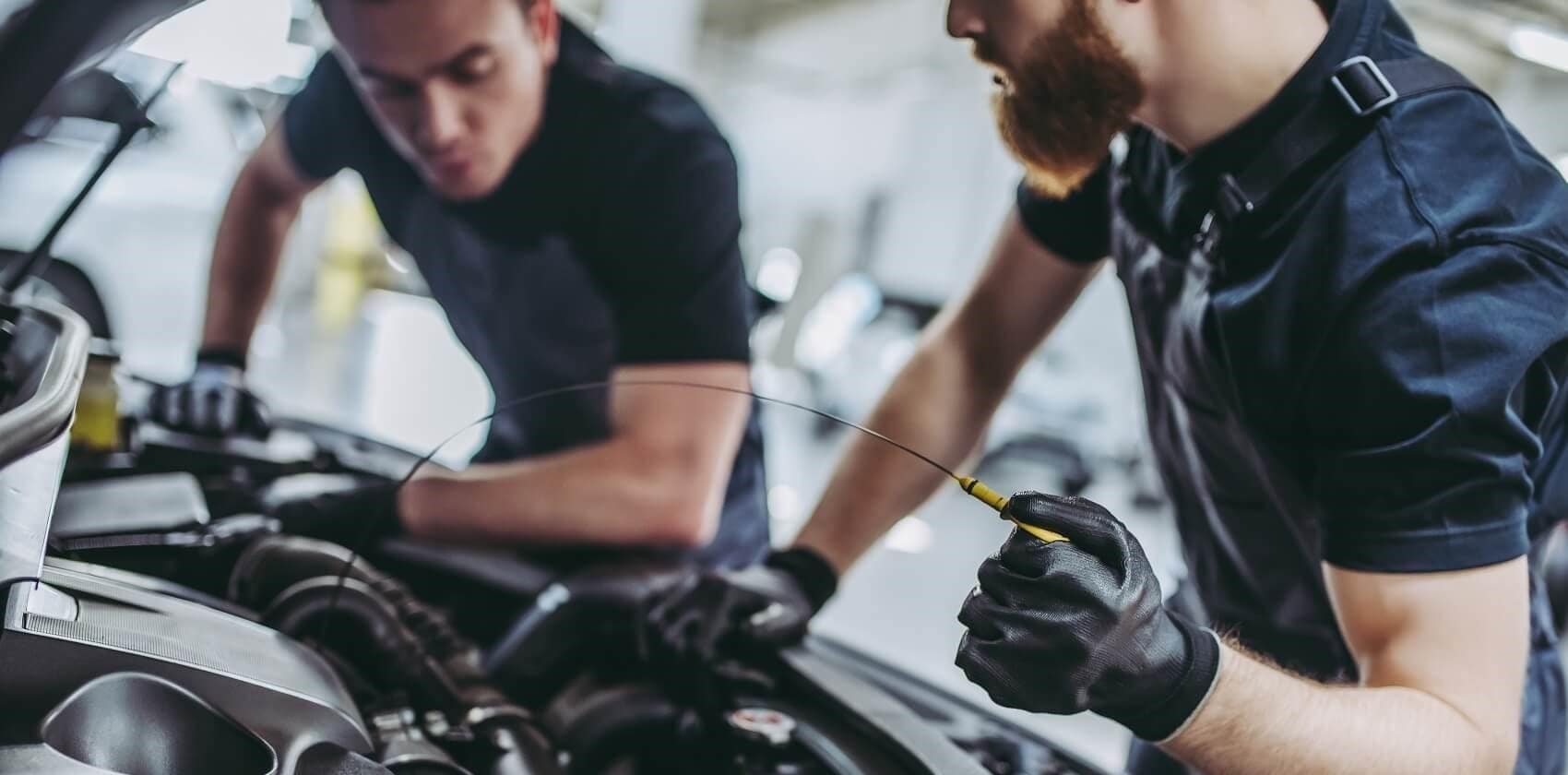 image of 2 mechanics working on a car
