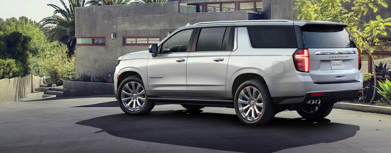 Rear of a white 2021 Chevy Suburban parked outside a building.