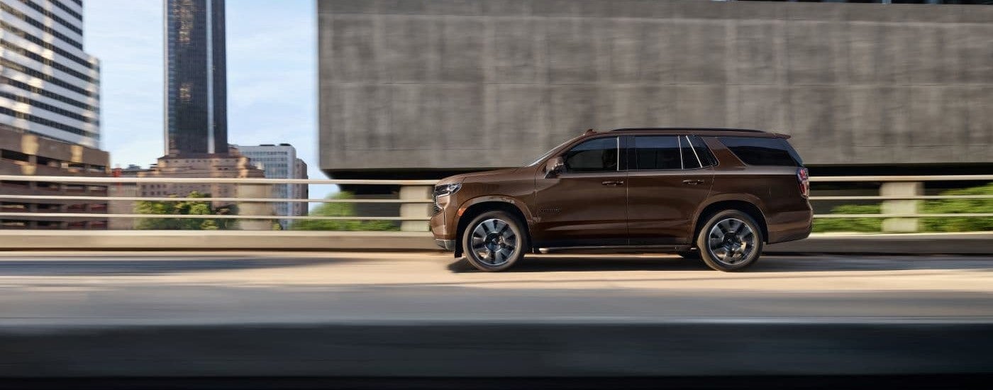 A brown 2022 Chevy Tahoe side-view driving.