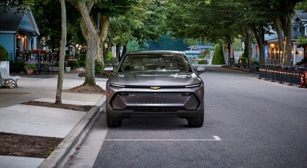 A silver 2024 Chevy Equinox EV 1LT parallel parked.
