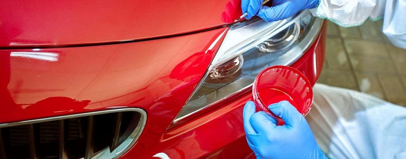 Red vehicle getting paint touched up