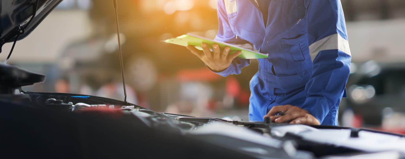Mechanic assessing a car engine.