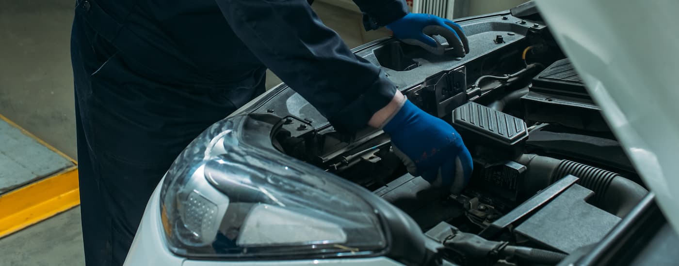 Mechanic performing a car battery replacement.