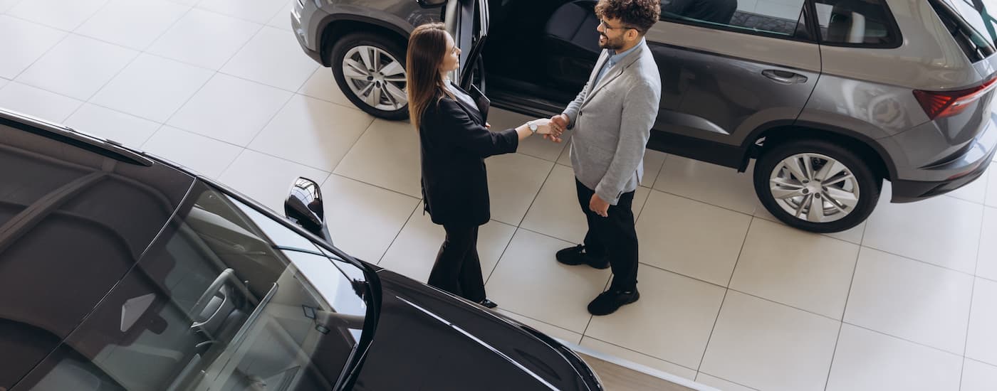 Saleswoman and customer discussing how to sell a vehicle