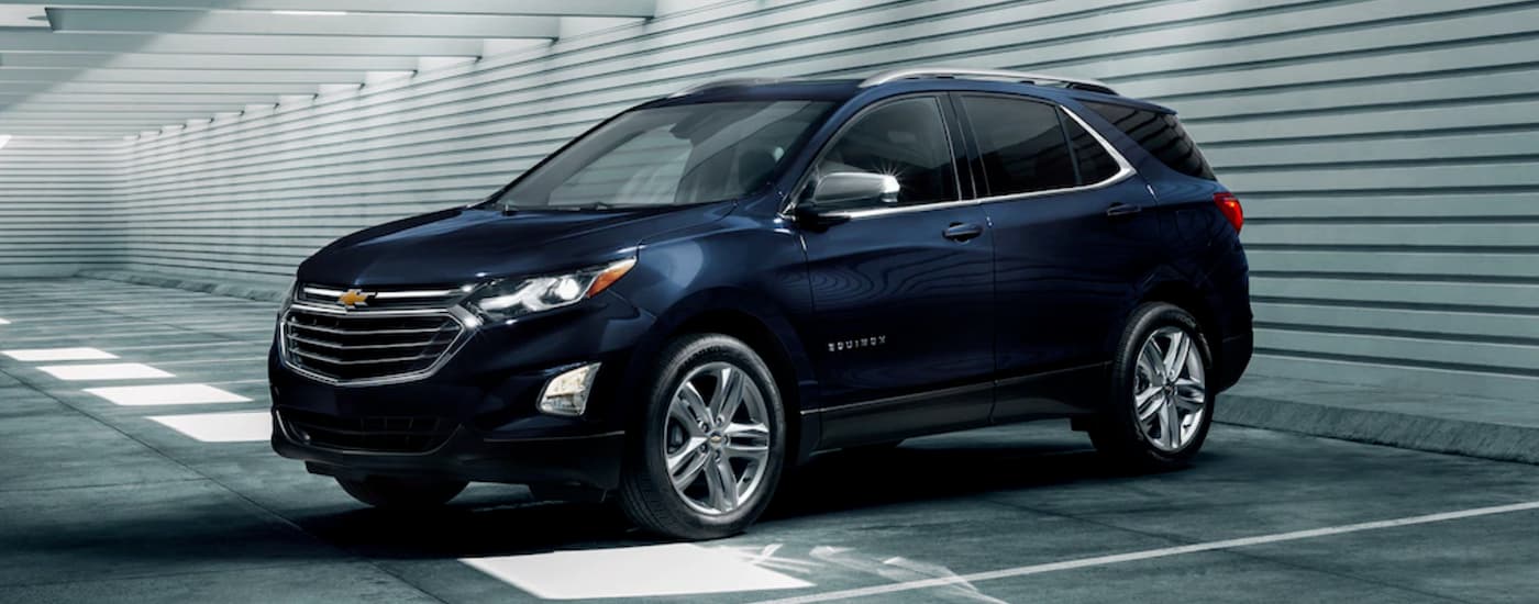 Dark blue 2020 Chevy Equinox parked on a parking lot at a used car dealership near Lansing.